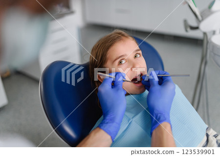 Cute girl during annual dental check-up in dental clinic. 123539901