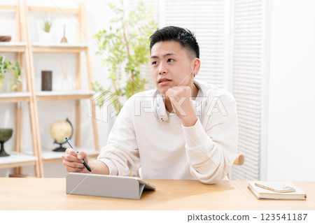Male teenager living room tablet studying Male teenager living room tablet studying 123541187