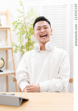 Male teenager living room tablet studying 123541197