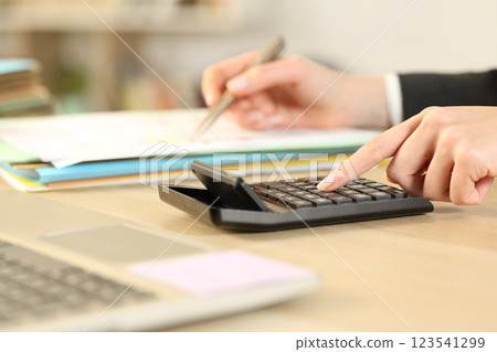 Woman at business accounting using calculator at office Woman at business accounting using calculator at office 123541299