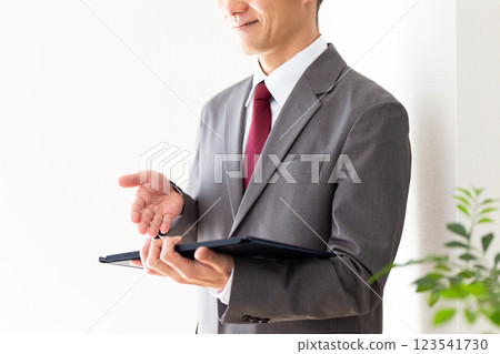 Middle-aged male businessman holding a clipboard Middle-aged male businessman holding a clipboard 123541730