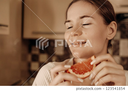 Woman Kitchen Grapefruit Joyful Taste: Healthy eating habits, enjoying citrus fruit at home. Woman Kitchen Grapefruit Joyful Taste: Healthy eating habits, enjoying citrus fruit at home. 123541854