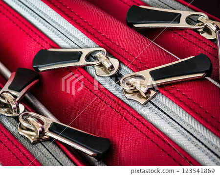 Bright red luggage showcasing detailed zippers ready for travel adventure during summer vacation Bright red luggage showcasing detailed zippers ready for travel adventure during summer vacation 123541869