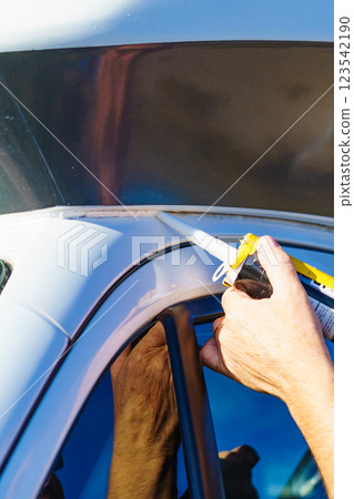 Applying silicon on caravan body 123542190