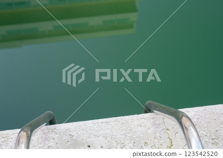 Swimming pool with dirty green water close-up. Swimming pool with dirty green water close-up. 123542520