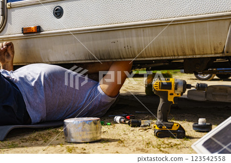 Man repairing bottom of the rv caravan Man repairing bottom of the rv caravan 123542558