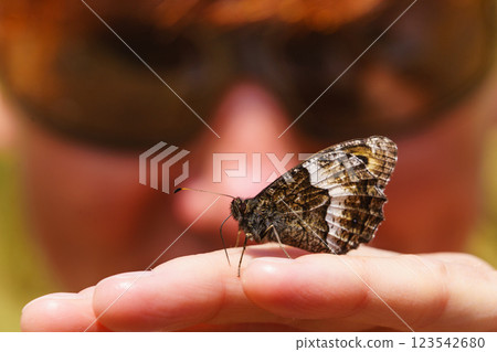 Butterfly sitting on the female hand 123542680