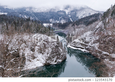 【只見線】冬日風景中行駛在只見川第一橋上的列車 123543170