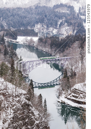 [Tadami Line] A train running over the First Tadami River Bridge in winter scenery 123543979