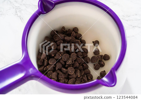 Making chocolate leaves from melted chocolate to decorate the pumpkin bundt cake. 123544084