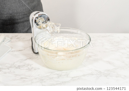 Preparing cream cheese frosting to ice the delicious pumpkin bundt cake. Preparing cream cheese frosting to ice the delicious pumpkin bundt cake. 123544171