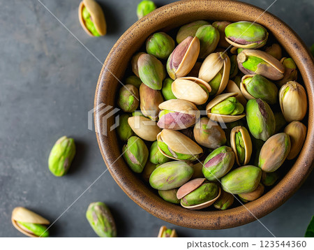 Rustic ceramic bowl filled with fresh pistachios, some still in shells Rustic ceramic bowl filled with fresh pistachios, some still in shells 123544360