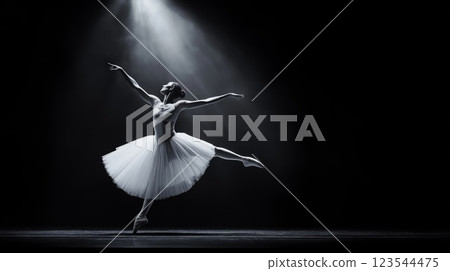 Ballerina dancing on stage with spotlight and tutu in black and white 123544475