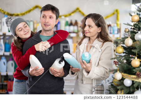 Happy family discussing choice of shower gel in Christmas decorated store 123544488