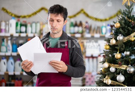 Bewildered man seller work with document, looks at report and is upset by results of stores work 123544531