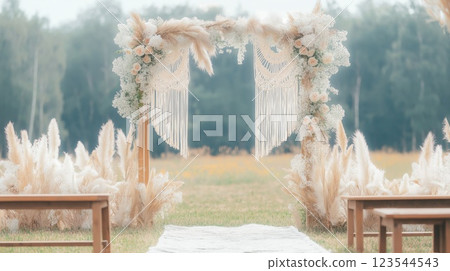 Wedding arch decorated with macrame and pampas grass in open field 123544543
