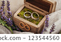 Wedding rings resting in rustic wooden box with lavender sprigs 123544560