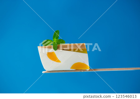 a piece of milky fruit jelly with pieces of fruit inside 123546013