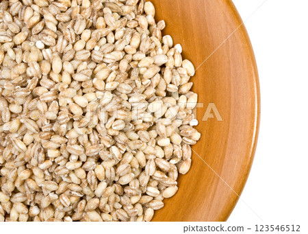 Pearl barley filling a wooden bowl on white background Pearl barley filling a wooden bowl on white background 123546512