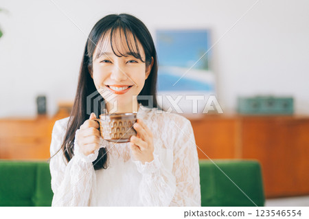 一個女人坐在沙發上，喝著咖啡 123546554