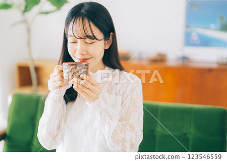 一個女人坐在沙發上，喝著咖啡 123546559