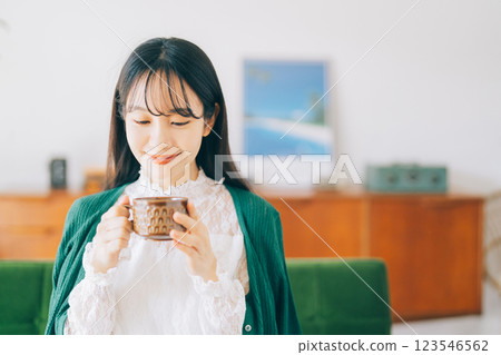 一個女人坐在沙發上，喝著咖啡 123546562