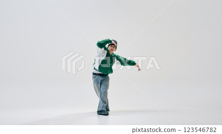 Hip-hop dancer, dressed stylish vintage jacket and jeans, smoothly transitioning between moves against white studio background. 123546782