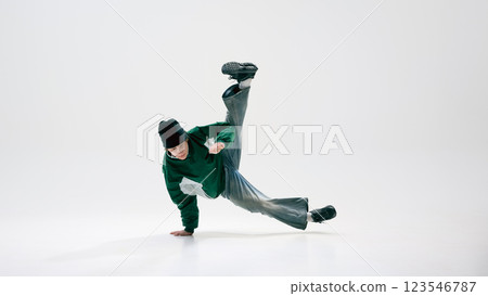Urban dancer, dressed vintage, executing acrobatic spin, defying gravity with precision against white background. Dance and music. Urban dancer, dressed vintage, executing acrobatic spin, defying gravity with precision against white background. Dance and music. 123546787