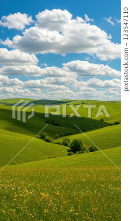 Idyllic green hills with blue sky and fluffy clouds in scenic landscape Idyllic green hills with blue sky and fluffy clouds in scenic landscape 123547110