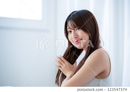 Young woman combing her hair with a hand comb Young woman combing her hair with a hand comb 123547374