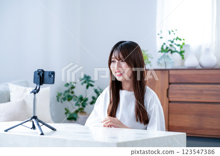 微笑的年輕女士拍攝視頻 微笑的年輕女士拍攝視頻 123547386