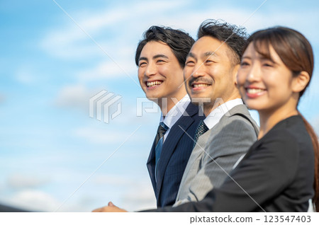 三位面帶微笑的商人並肩站著 三位面帶微笑的商人並肩站著 123547403