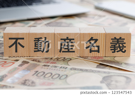 Block with the word "real estate title" written on top of money Block with the word "real estate title" written on top of money 123547543