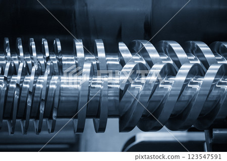 Close up scene body of the barrel screw of injection machine spare parts in the light blue scene. Close up scene body of the barrel screw of injection machine spare parts in the light blue scene. 123547591