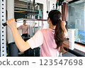 Woman doing muscle training with lat pulldown 123547698