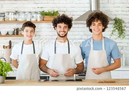 Three sons actively participating in kitchen preparations during a family cooking session 123548567