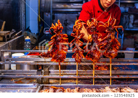 Fried oily cooked calamari at the night seafood cuisine street downtown market, Xian, Shaanxi province, China Fried oily cooked calamari at the night seafood cuisine street downtown market, Xian, Shaanxi province, China 123548925