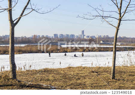 Men fishing on the frozen pond Men fishing on the frozen pond 123549018