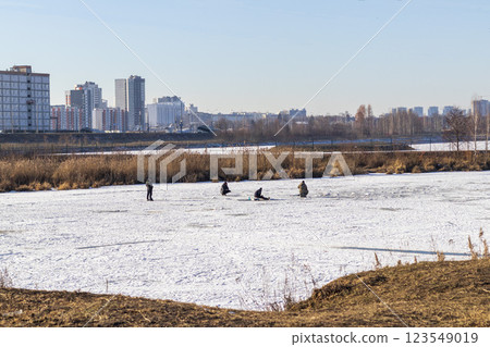 Men fishing on the frozen pond 123549019