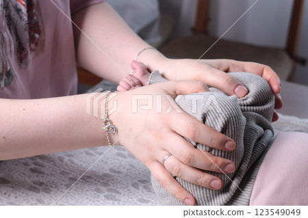 Loving young mother making massage to cute newborn baby on table. Infant health and strengthening exercises at home. Loving young mother making massage to cute newborn baby on table. Infant health and strengthening exercises at home. 123549049