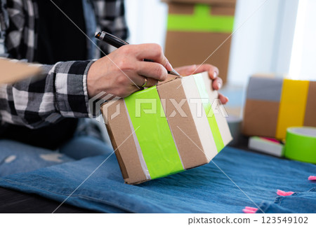 Girl Preparing Cardboard Box For Shipping 123549102