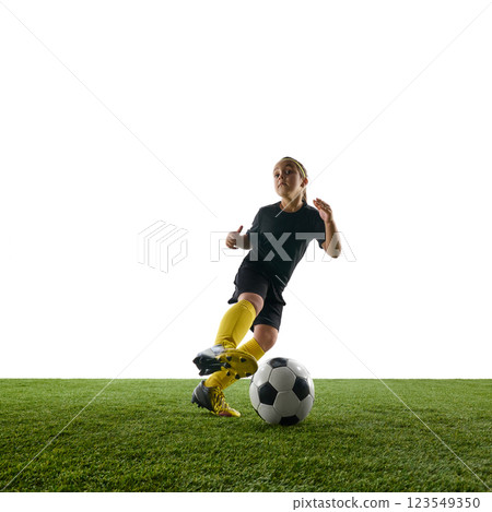 Dynamic image of motivated child, girl in sportswear in motion on field, training, playing soccer against white studio background Dynamic image of motivated child, girl in sportswear in motion on field, training, playing soccer against white studio background 123549350
