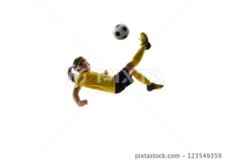 Dynamic image of competitive child, girl in uniform, playing soccer game, hitting ball in motion and falling down against white studio background Dynamic image of competitive child, girl in uniform, playing soccer game, hitting ball in motion and falling down against white studio background 123549359