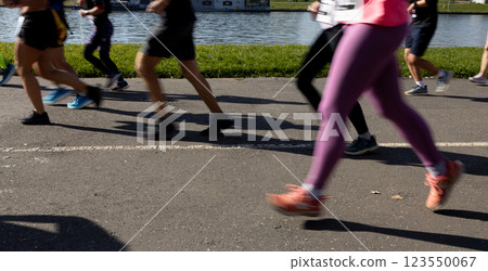 Motion blurred marathon runners in a city. Group of marathon runners compete in the race outdoors Motion blurred marathon runners in a city. Group of marathon runners compete in the race outdoors 123550067