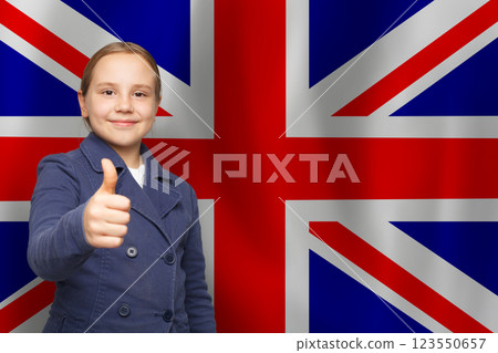 Cute child with thumb up on UK flag background. Education and childhood in United Kingdom concept 123550657