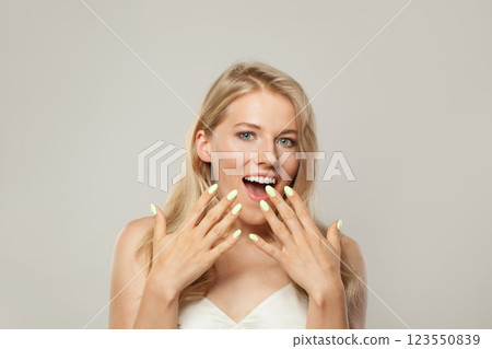 Happy surprised excited woman. Female model with blond hairstyle and clean skin, facial treatment 123550839