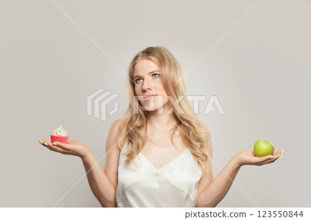 Attractive woman choosing between healthy food and junk food, diet concep 123550844