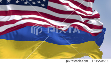 Close-up of Ukraine and US national flags waving on a clear day Close-up of Ukraine and US national flags waving on a clear day 123550865