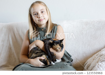 Pretty child girl with cat at home. Friends. Kid and pet. 123550968