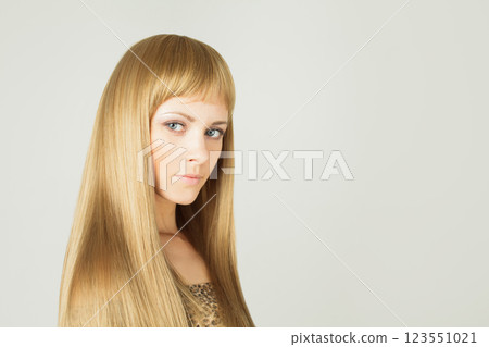 Natural young blond woman with long shiny silky healthy hair and natural make-up posing  123551021
